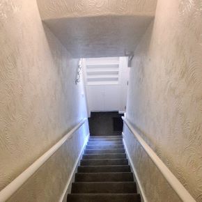 Professional painter applying emulsion and gloss to a staircase in a Clitheroe home